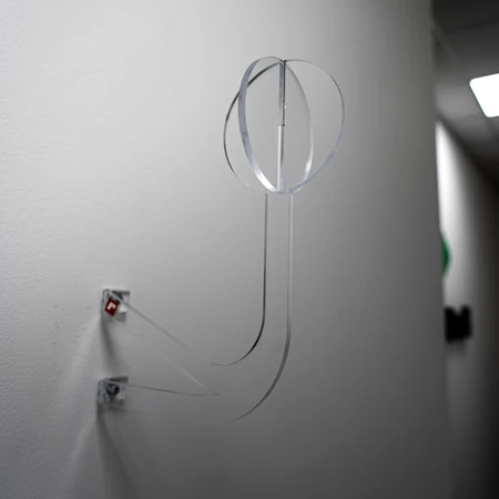 Portacasco in plexiglass realizzato in due pezzi e fissato a una parete, personalizzabile con adesivi